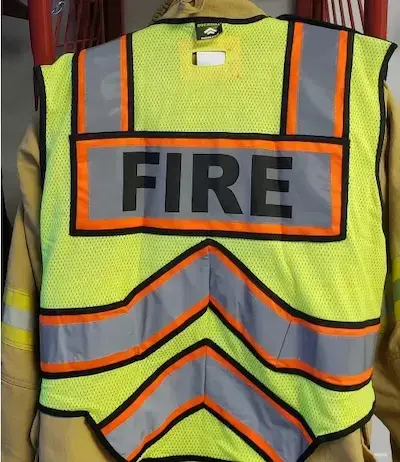 Fire Ninja orange and black public safety vest providing high-visibility protection for firefighters during roadway and emergency operations.